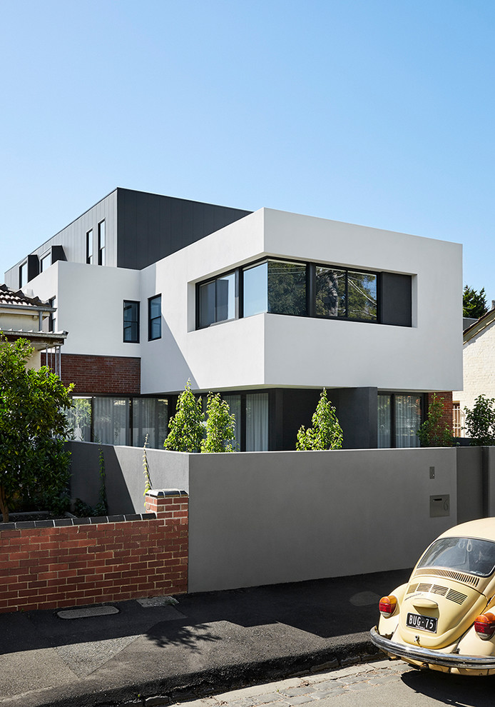 This is an example of a small and white contemporary terraced house in Melbourne with three floors, a flat roof and a metal roof.