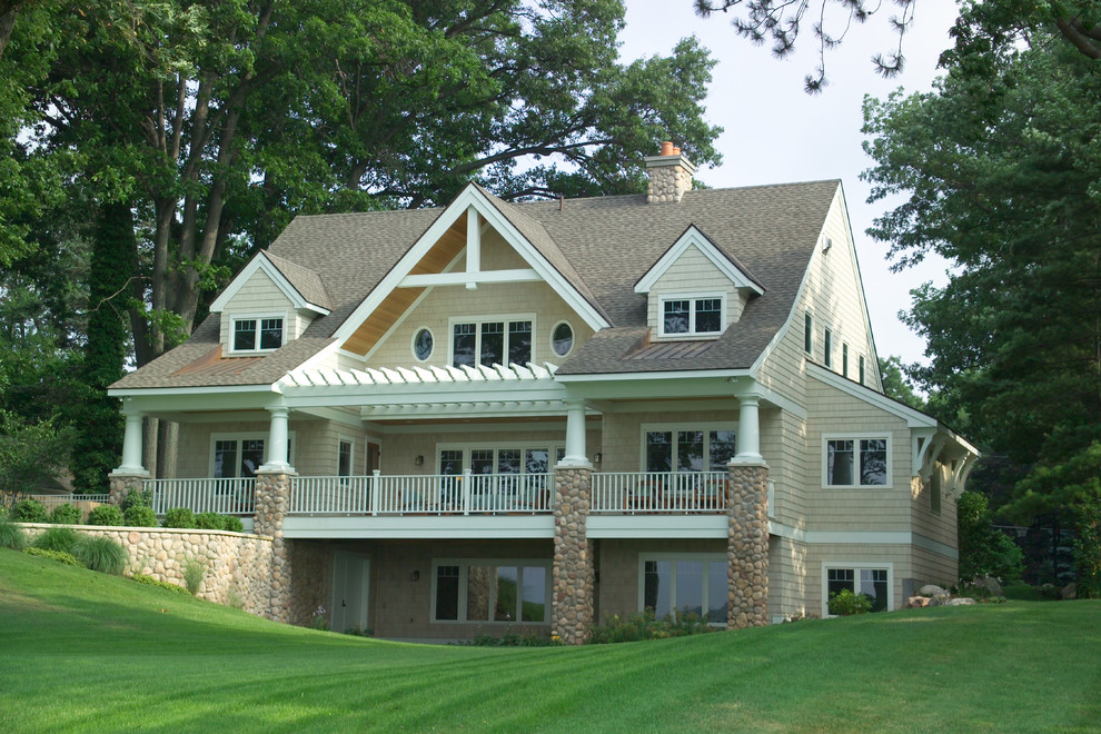 Exemple d'une grande façade de maison beige chic en panneau de béton fibré à deux étages et plus avec un toit à deux pans.