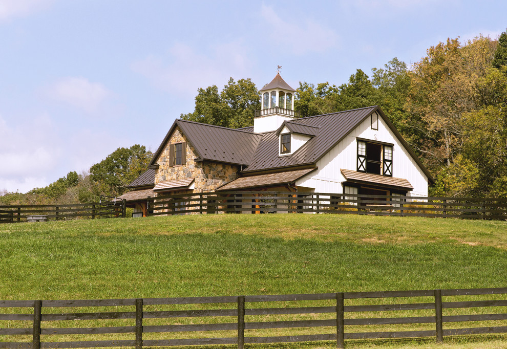 Modelo de fachada blanca de estilo de casa de campo de tamaño medio de dos plantas con revestimientos combinados, tejado a dos aguas y tejado de metal