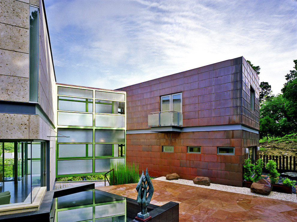 This is an example of a large and multi-coloured contemporary two floor house exterior in Austin with metal cladding, a flat roof and a metal roof.