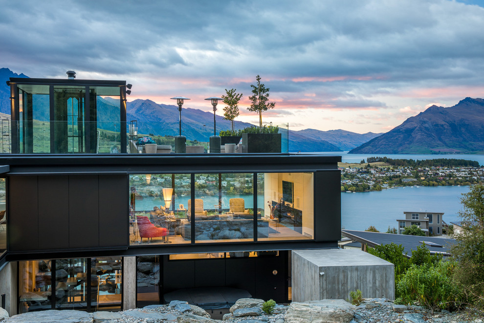 Zweistöckiges Modernes Einfamilienhaus mit schwarzer Fassadenfarbe und Flachdach in Sonstige