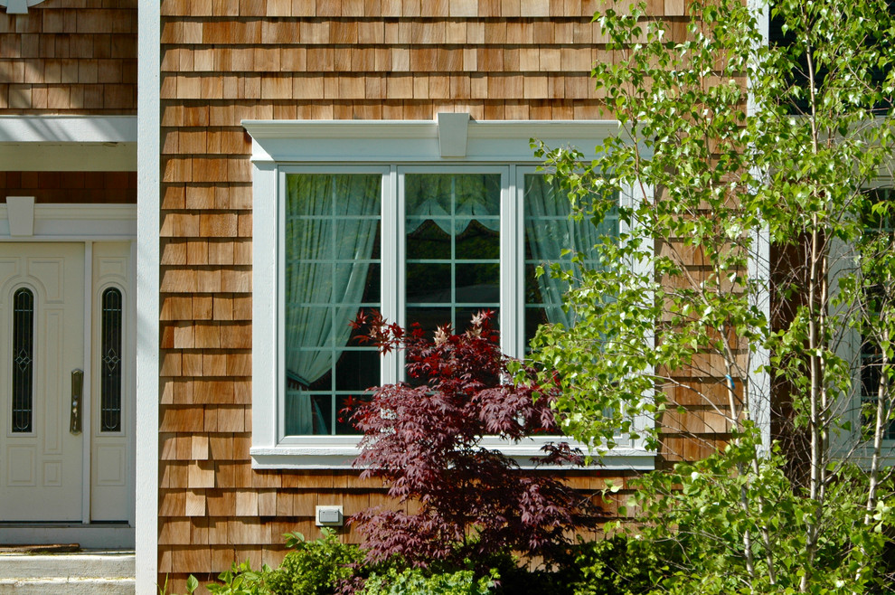На фото: коричневый, трехэтажный, деревянный дом среднего размера в стиле кантри