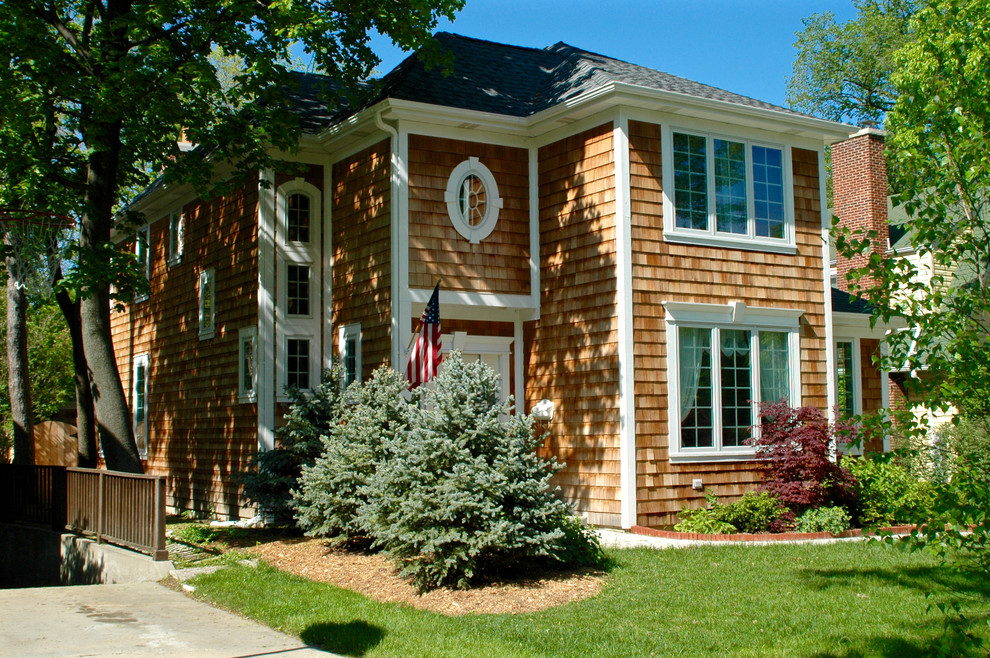 Ejemplo de fachada marrón de estilo americano de tamaño medio de tres plantas con revestimiento de madera