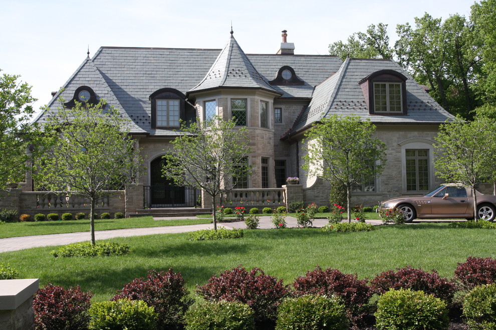 Photo of an expansive and beige classic two floor detached house in Chicago with stone cladding, a mansard roof and a shingle roof.