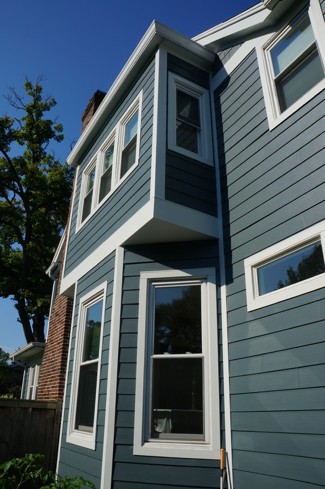 Cette image montre une grande façade de maison bleue rustique en panneau de béton fibré à deux étages et plus.