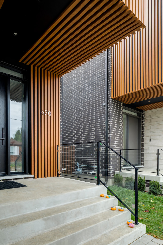 Kleines, Zweistöckiges Modernes Einfamilienhaus mit Backsteinfassade, schwarzer Fassadenfarbe, Flachdach und Wandpaneelen in Toronto