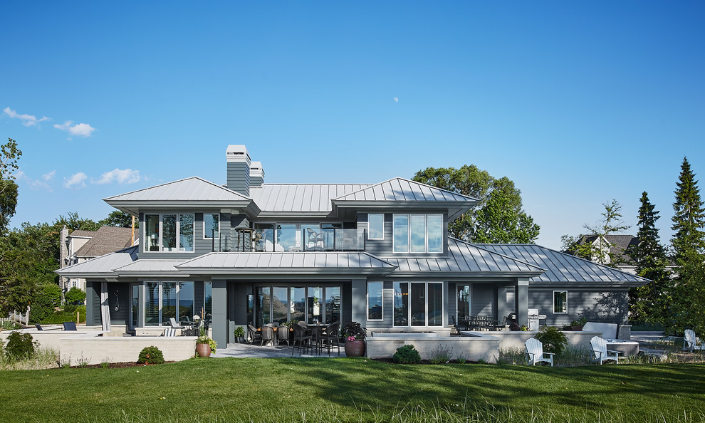 Inspiration för stora moderna grå hus, med tre eller fler plan, valmat tak och tak i metall
