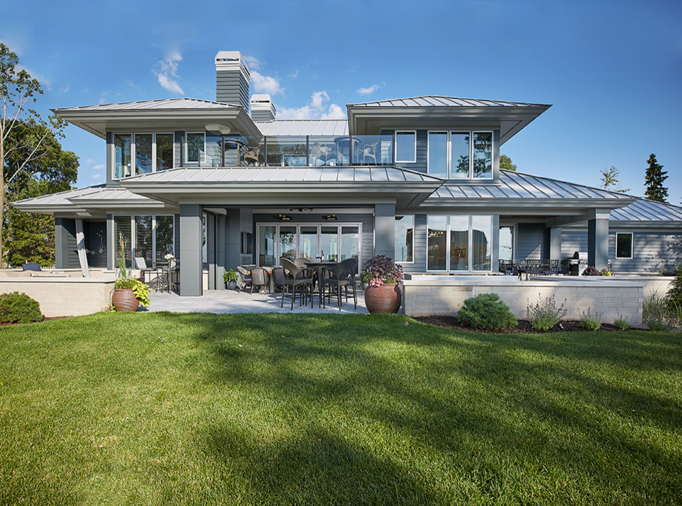 Großes, Dreistöckiges Modernes Einfamilienhaus mit grauer Fassadenfarbe, Metallfassade, Walmdach und Blechdach in Grand Rapids