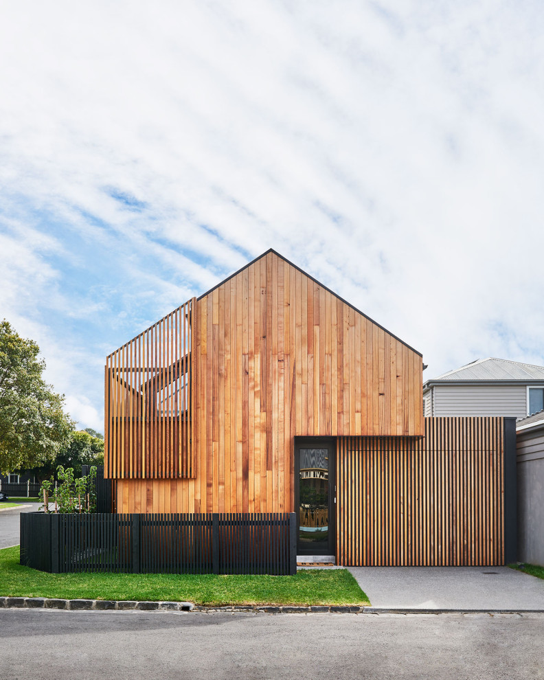 This is an example of a black contemporary two floor terraced house in Geelong with wood cladding, a pitched roof and a metal roof.