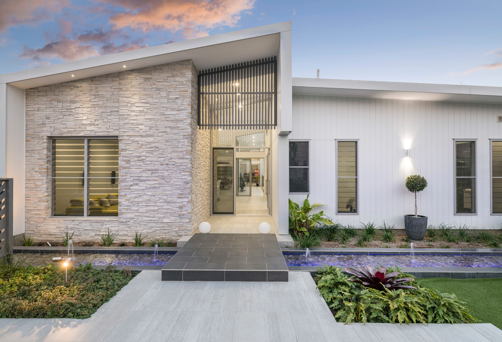 Свежая идея для дизайна: белый, одноэтажный частный загородный дом в современном стиле с комбинированной облицовкой и односкатной крышей - отличное фото интерьера