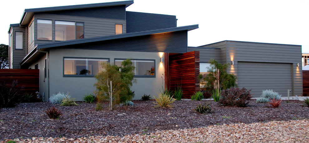 Diseño de fachada de casa gris actual de tamaño medio de dos plantas con revestimiento de metal y tejado de metal