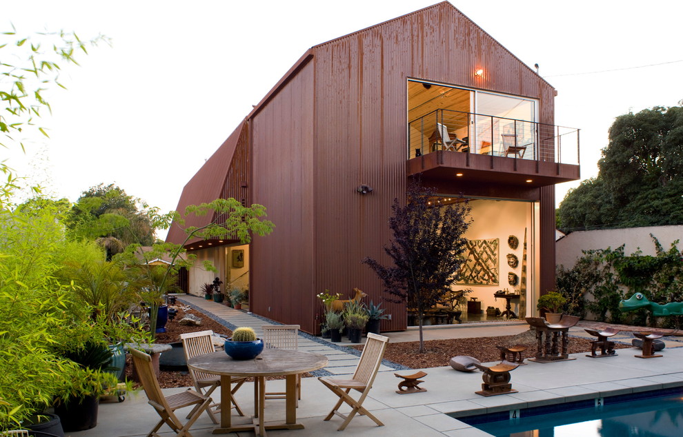 Diseño de fachada de casa roja moderna de dos plantas con revestimiento de metal, tejado a dos aguas y tejado de metal