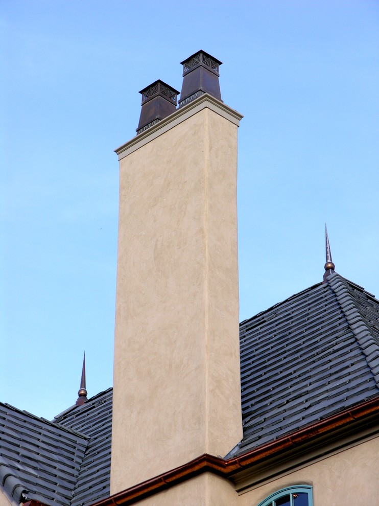 Imagen de fachada clásica de dos plantas con revestimiento de estuco