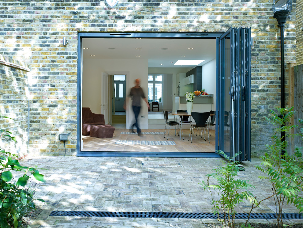 Photo of a medium sized and white contemporary brick house exterior in London with three floors.