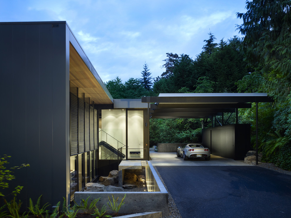 Inspiration för mellanstora moderna svarta hus i flera nivåer, med metallfasad och platt tak