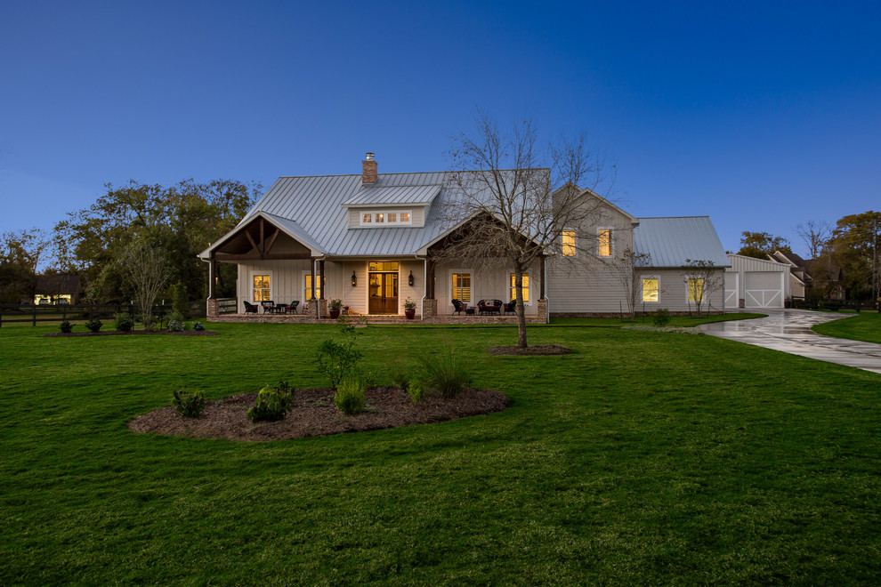 Einstöckiges Landhausstil Einfamilienhaus mit grauer Fassadenfarbe, Satteldach und Blechdach in Houston