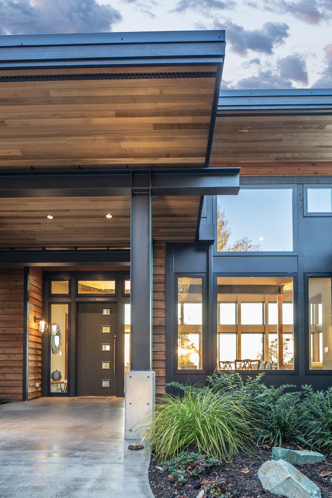 Ejemplo de fachada de casa marrón minimalista de tamaño medio de una planta con revestimientos combinados, tejado de un solo tendido y tejado de metal