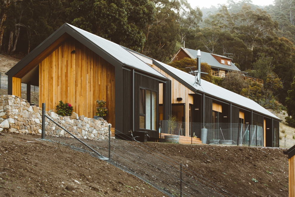 Ispirazione per la villa contemporanea con rivestimento in legno e copertura in metallo o lamiera