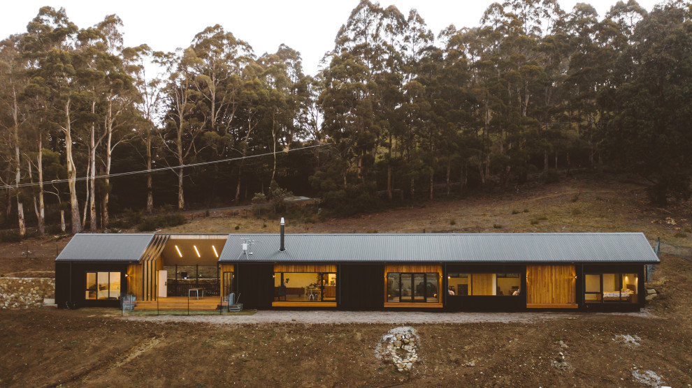 This is an example of a contemporary detached house in Hobart with wood cladding and a metal roof.