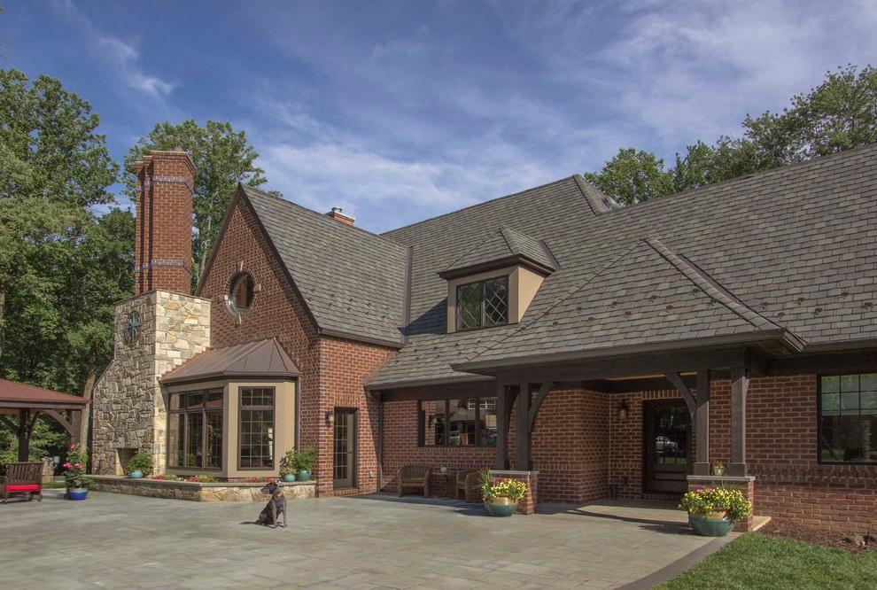 Inspiration for a large timeless red two-story brick house exterior remodel in DC Metro with a hip roof and a shingle roof