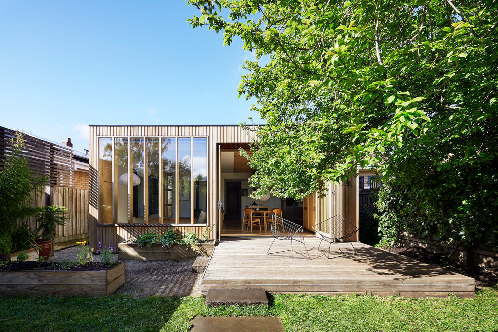Cette photo montre une petite façade de maison marron tendance en bois de plain-pied avec un toit plat.