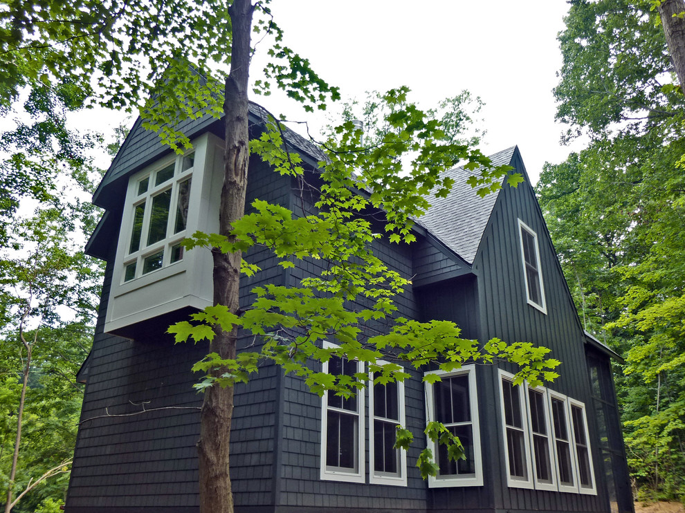 Réalisation d'une façade de maison verte nordique en panneau de béton fibré à un étage avec un toit à deux pans.