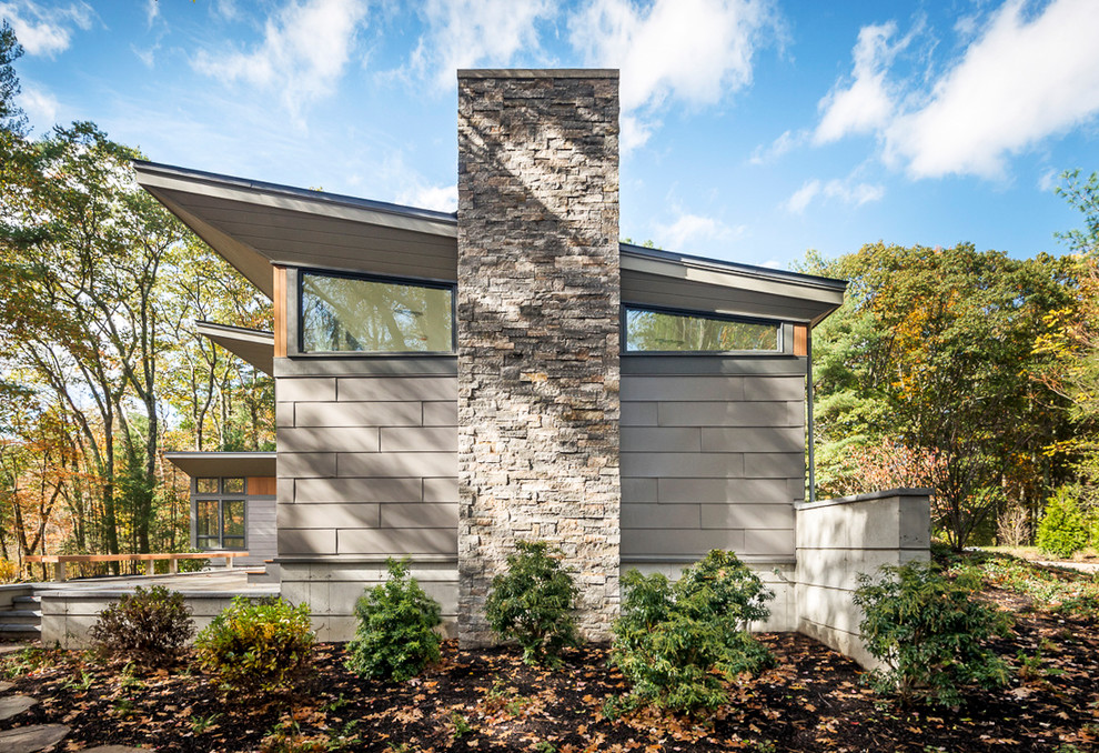 Diseño de fachada de casa gris actual de dos plantas con revestimiento de metal y tejado de un solo tendido