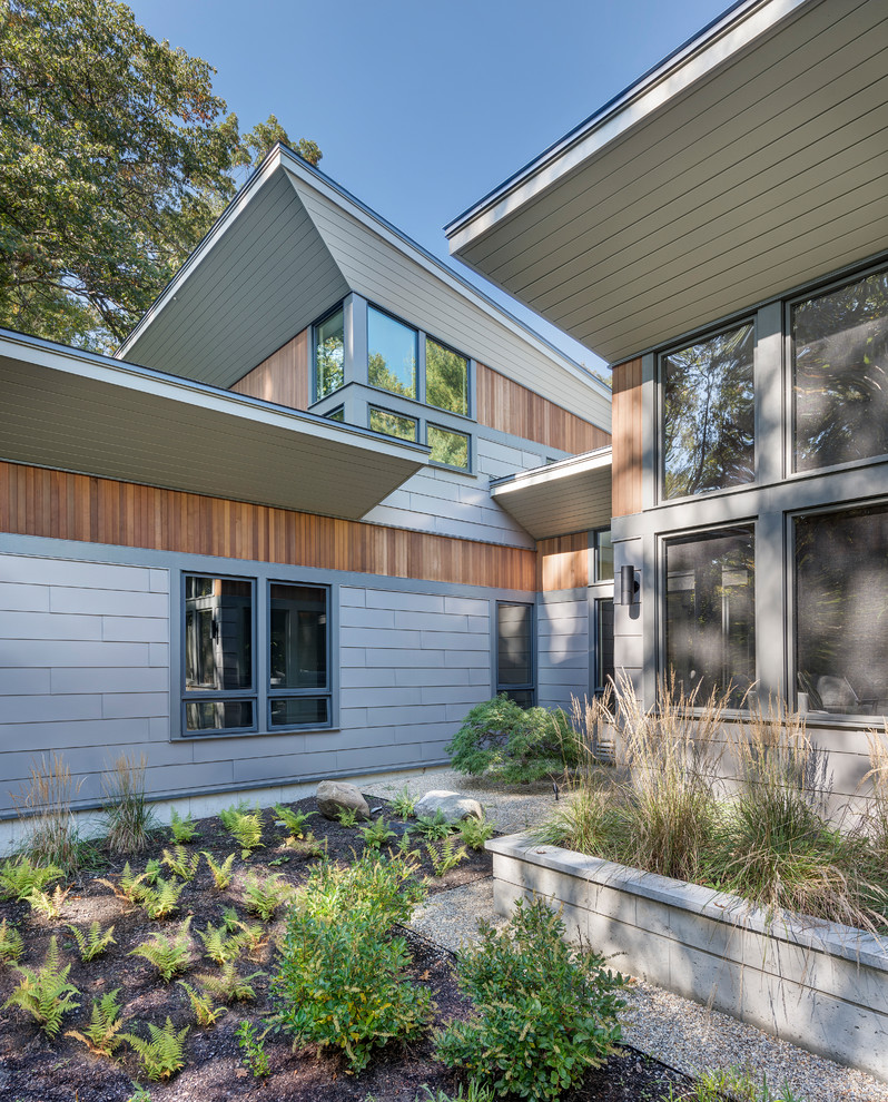 Свежая идея для дизайна: двухэтажный, серый частный загородный дом в современном стиле с облицовкой из металла и односкатной крышей - отличное фото интерьера