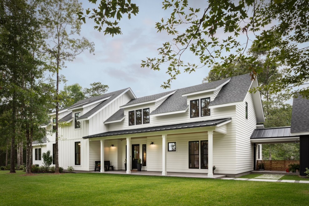 Large country white two-story wood house exterior photo in New Orleans with a clipped gable roof and a shingle roof