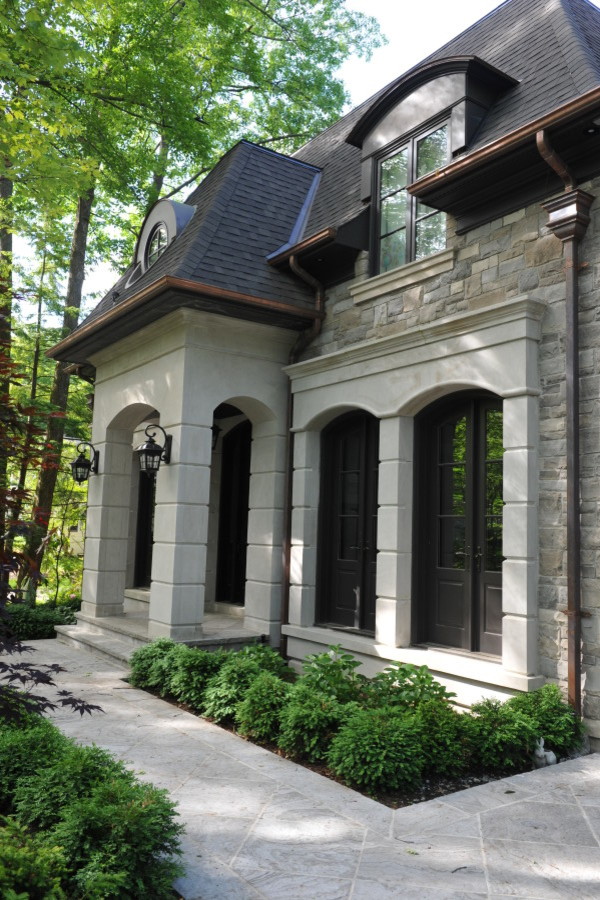Inspiration pour une grande façade de maison grise traditionnelle en pierre à un étage avec un toit en shingle.