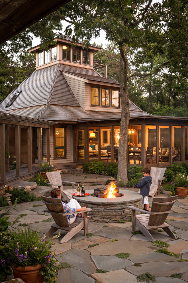 Photo of a rustic house exterior in Boston with wood cladding and a hip roof.
