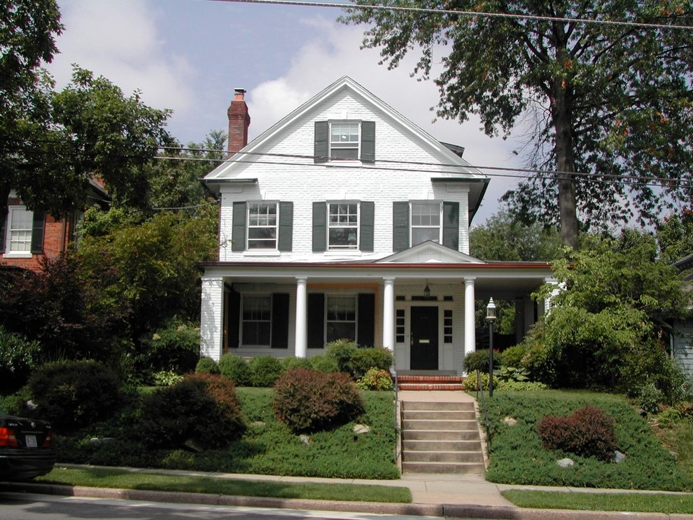 Photo of a medium sized and white traditional brick house exterior in DC Metro with three floors and a pitched roof.