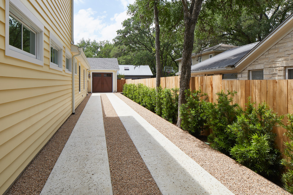Großes, Zweistöckiges Landhaus Haus mit gelber Fassadenfarbe, Satteldach und Schindeldach in Austin