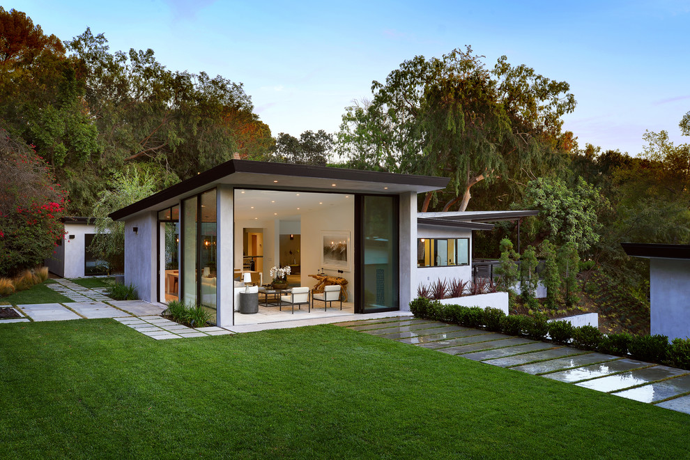 Réalisation d'une façade de maison grise minimaliste en béton de taille moyenne et de plain-pied avec un toit plat.