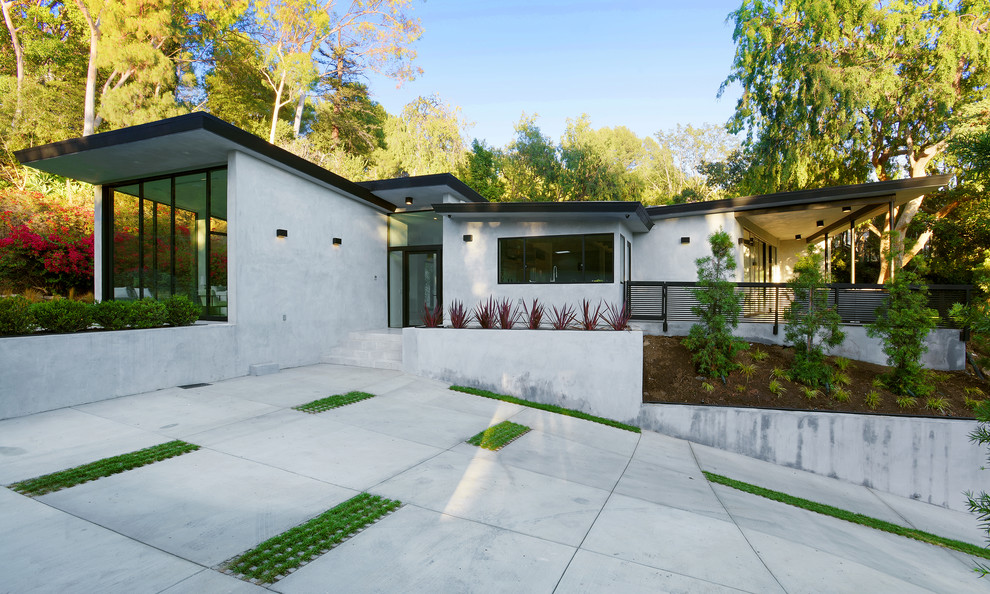Idée de décoration pour une façade de maison grise minimaliste en béton de taille moyenne et de plain-pied avec un toit plat.