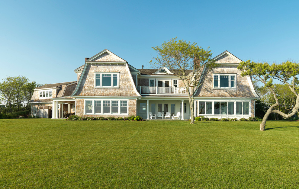 Inspiration for a large timeless brown two-story wood house exterior remodel in Other with a gambrel roof and a shingle roof
