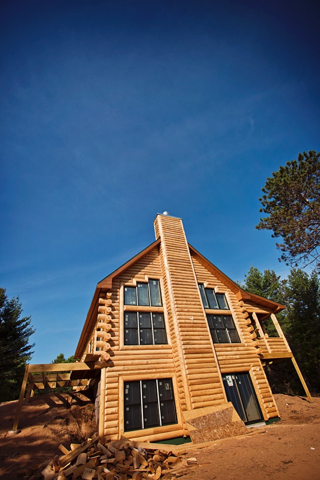 Ejemplo de fachada de casa marrón rústica de tamaño medio de dos plantas con revestimiento de madera, tejado a dos aguas y tejado de teja de madera