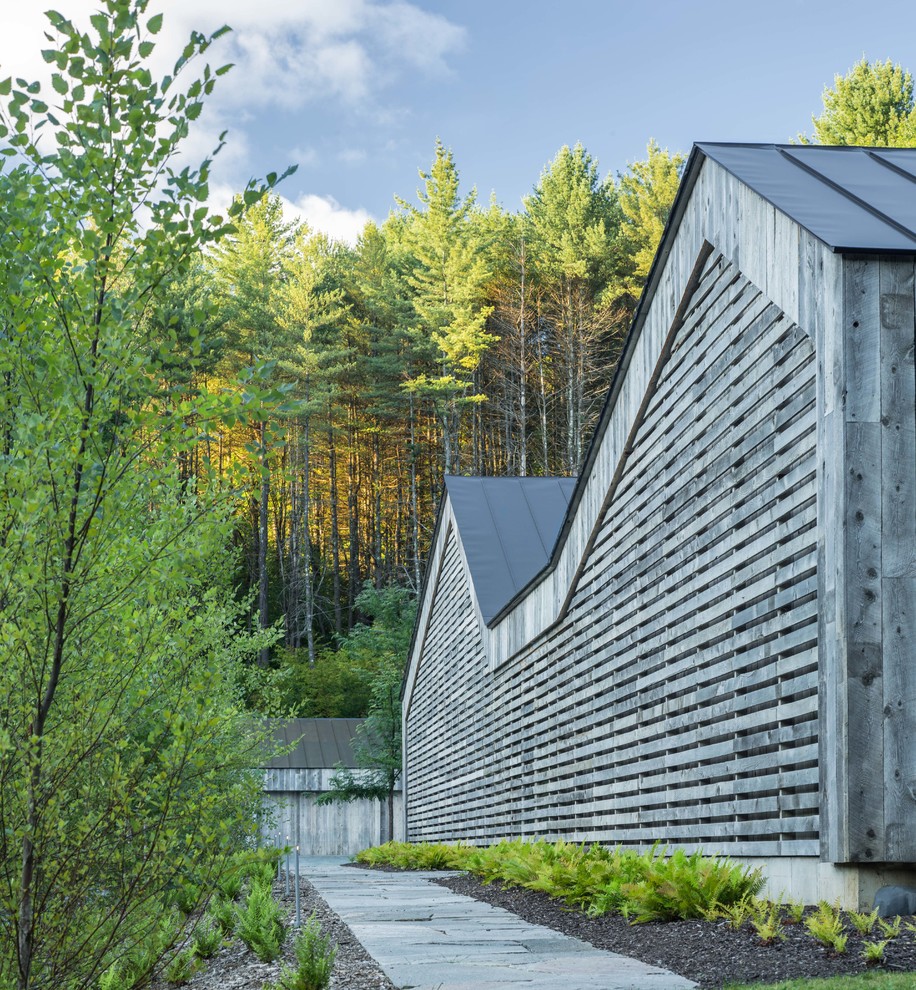 Aménagement d'une façade de maison grise contemporaine en bois de taille moyenne et de plain-pied avec un toit à deux pans et un toit en métal.