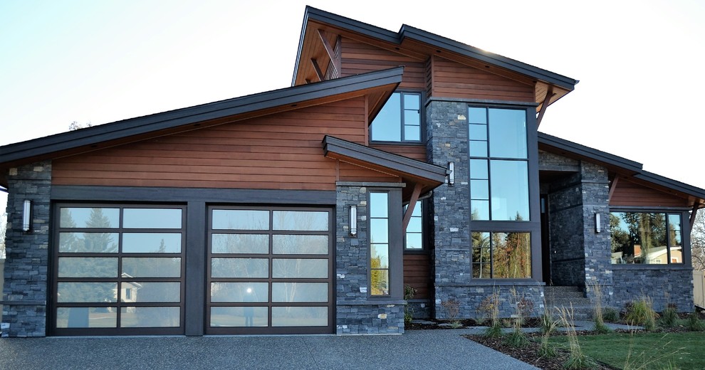 Cette photo montre une grande façade de maison marron tendance à un étage avec un revêtement mixte et un toit en appentis.