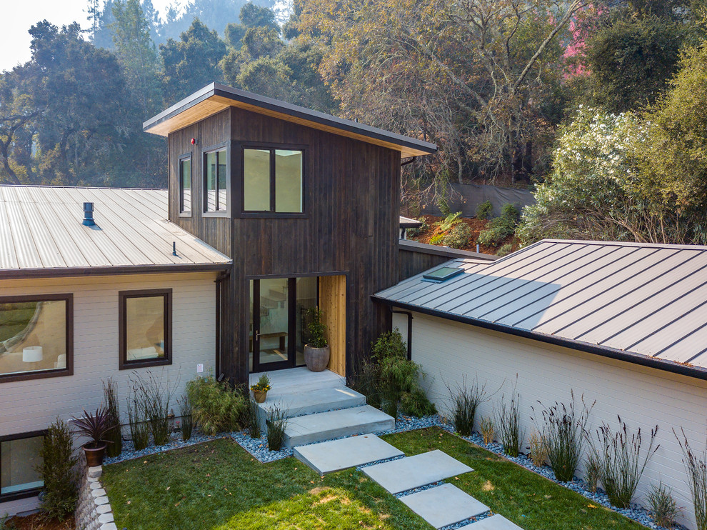Inspiration for a mid-sized contemporary brown three-story mixed siding house exterior remodel in San Francisco with a shed roof and a metal roof