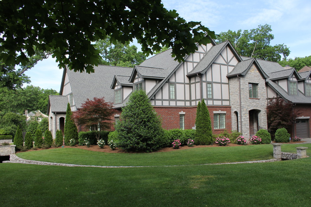 This is an example of a large and multi-coloured classic two floor brick semi-detached house in Nashville with a pitched roof and a shingle roof.