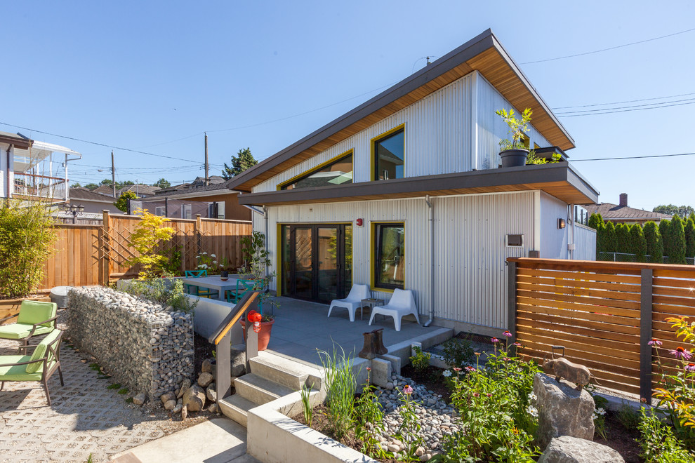 Zweistöckiges, Mittelgroßes Industrial Einfamilienhaus mit Metallfassade, grauer Fassadenfarbe, Pultdach und Blechdach in Vancouver