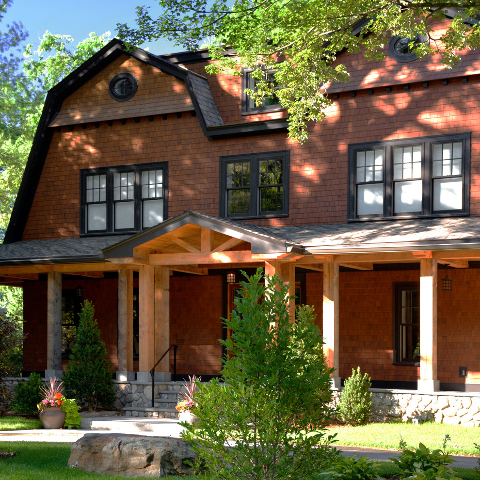 Example of a large classic brown three-story wood exterior home design in Boston with a gambrel roof