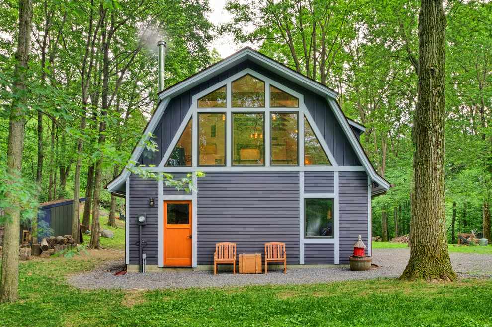 Diseño de fachada gris campestre de dos plantas con revestimiento de madera y tejado a doble faldón
