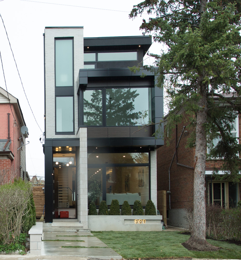 Small minimalist white three-story mixed siding exterior home photo in Toronto with a metal roof