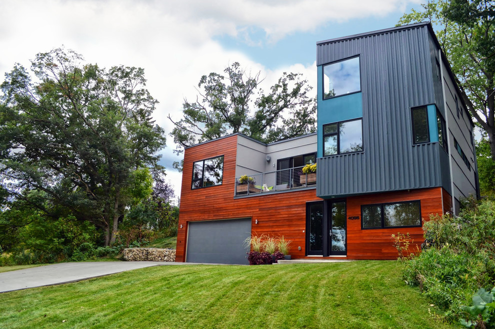 На фото: двухэтажный, синий дом в стиле модернизм с комбинированной облицовкой с