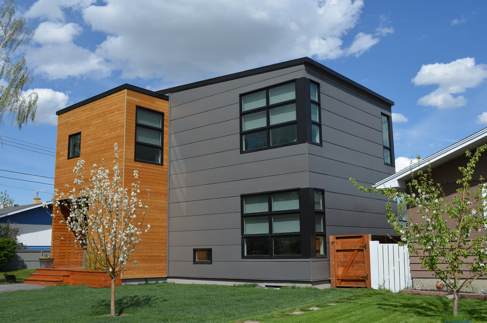 Design ideas for a gey modern two floor house exterior in Calgary with mixed cladding.
