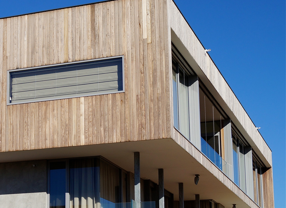 Ispirazione per la facciata di una casa grande moderna a un piano con rivestimento in legno e tetto piano