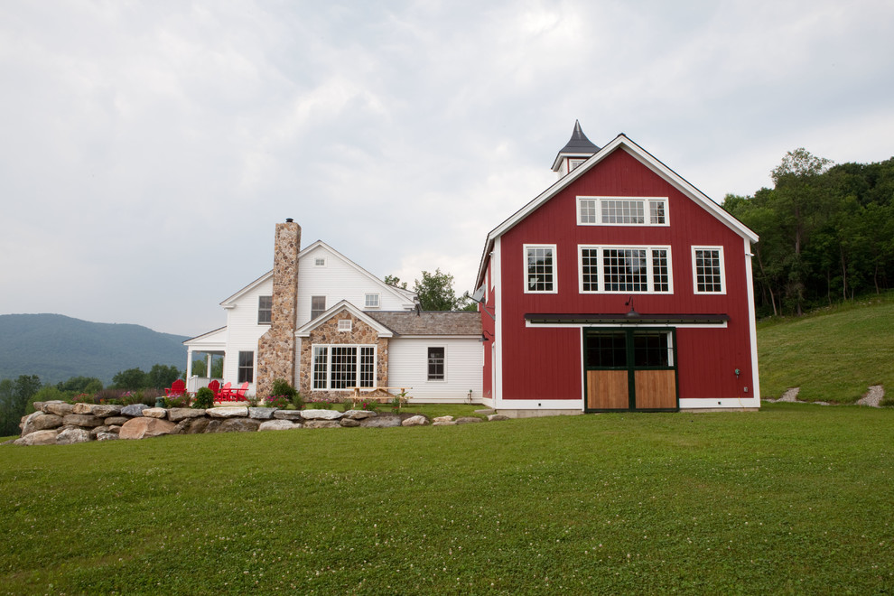 Diseño de fachada roja tradicional grande de dos plantas con revestimiento de madera y tejado a dos aguas