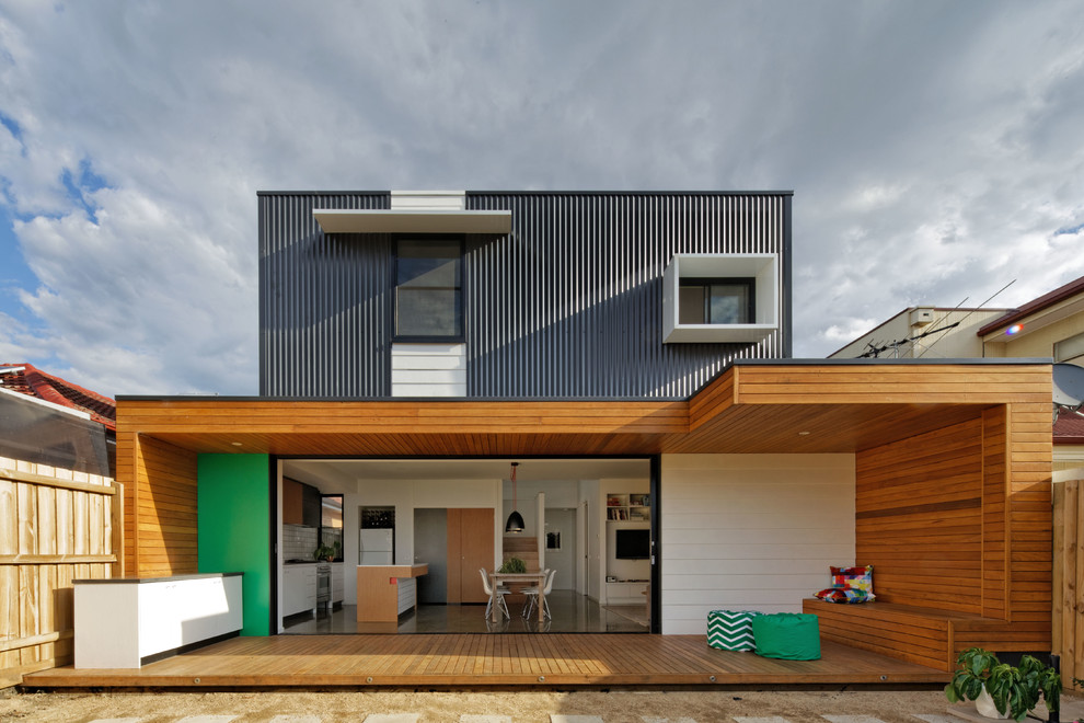 Идея дизайна: маленький, двухэтажный, черный дом в современном стиле с облицовкой из металла и плоской крышей для на участке и в саду